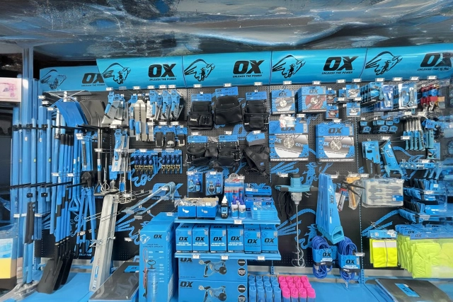 A retail display wall featuring a wide variety of OX brand hand tools and construction equipment
